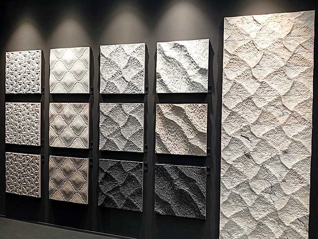 Parete espositiva dello stand Petra con formelle e lastre in pietra scolpita 3D a Cersaie 2026